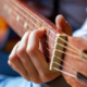 900-young-hipster-woman-hands-playing-guitar-at-home-teen-girl-learning-to-play-song-and-writing-music-in-her-room-hobby-lifestyle-relax-instrument-leisure-education-concept