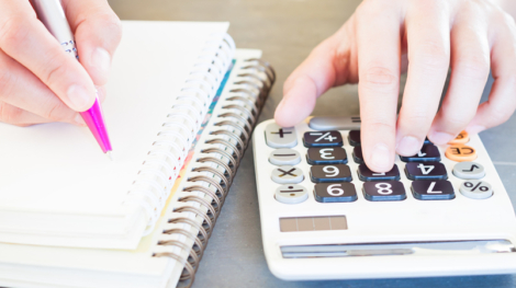 900-close-up-of-a-person-using-a-calculator-and-writing-in-a-notebook