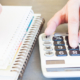900-close-up-of-a-person-using-a-calculator-and-writing-in-a-notebook