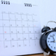 900_medium-vecteezy_calendar-with-days-and-clock-on-wood-table_7182315_medium