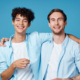 900-man-with-curly-hair-hugs-his-friend-on-blue-background-fun-cropped-view