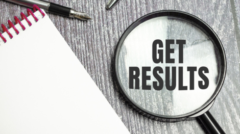 900-get-results-symbol-on-magnifier-and-pen-on-wooden-background-1