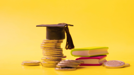 900-graduated-cap-with-coins-and-books-on-yellow-background-savings-for-education-concept