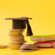 900-graduated-cap-with-coins-and-books-on-yellow-background-savings-for-education-concept